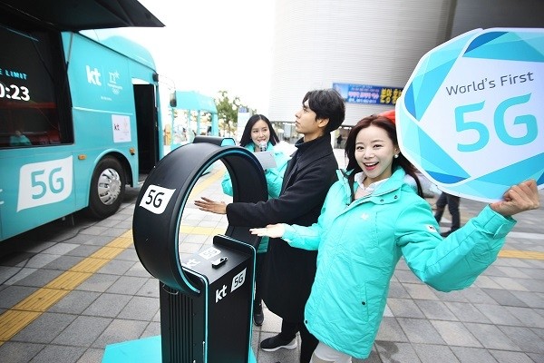 관람객이 KT 성화봉송단 ‘KT 챌린저스’와 함께 5G 이동형 홍보관 외부에서 5G 초저지연 기반의 리얼 타임 챌린지 서비스를 체험하고 있다.