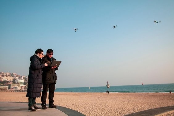 SK텔레콤 직원들이 해운대 해수욕장에서 드론으로 조난자 위치 수색 시연을 하고 있다. [제공=SK텔레콤]